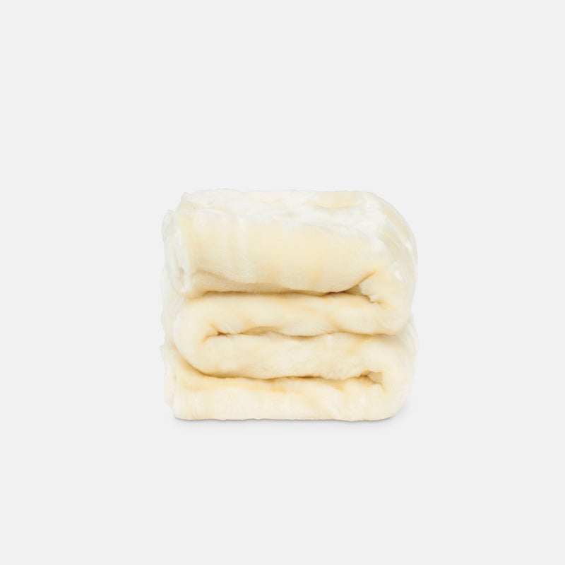 small folded minimink milk faux fur blanket on cream background