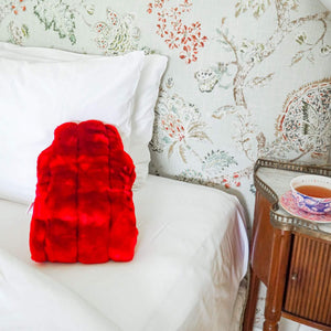 minimink cherry red faux fur hot water bottle cover sitting on bed
